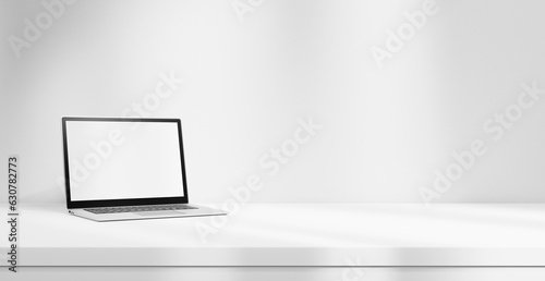 Laptop mock up with white blank screen on white table isolated on white background with light beams empty space. laptop and studying, office concept, empty white table stage with laptop