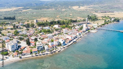 Aerial view of houses on the coastline against the sea on a sunny day