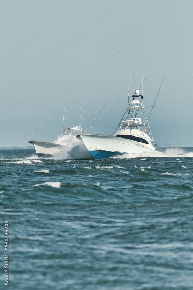Pair of fishing vessels navigating through the choppy waters of the open ocean Pair of fishing vessels navigating through the choppy waters of the open ocean