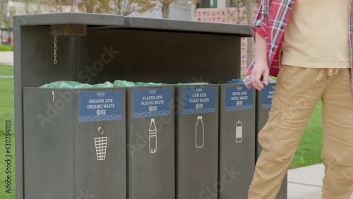 Man throws plastic bottle into trash bin photo