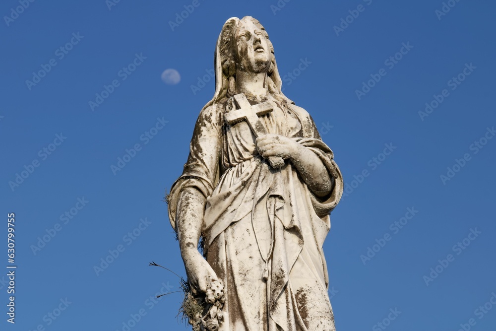 Majestic, stone statue stands in the foreground against a backdrop of a clear sky