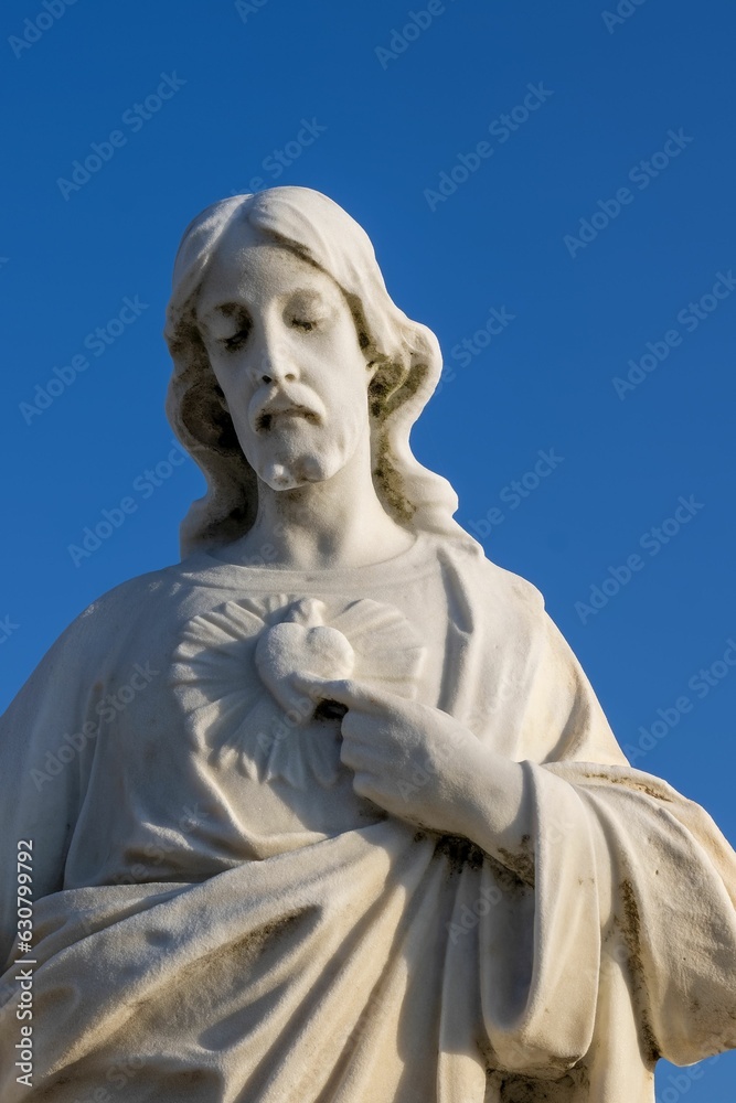 White statue of Jesus against a backdrop of a bright blue sky