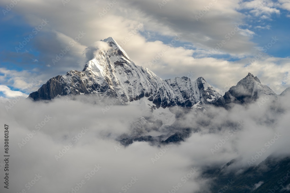 Breathtaking view of a snow-capped mountain adorned with clouds