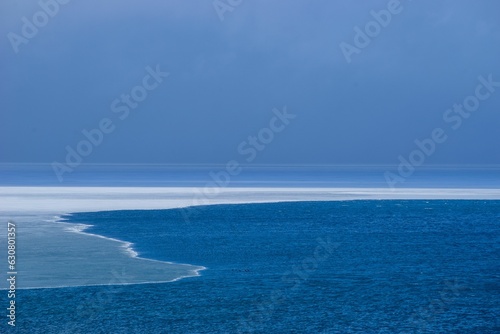 Calm view of a blue lake with the ice melting in the early spring