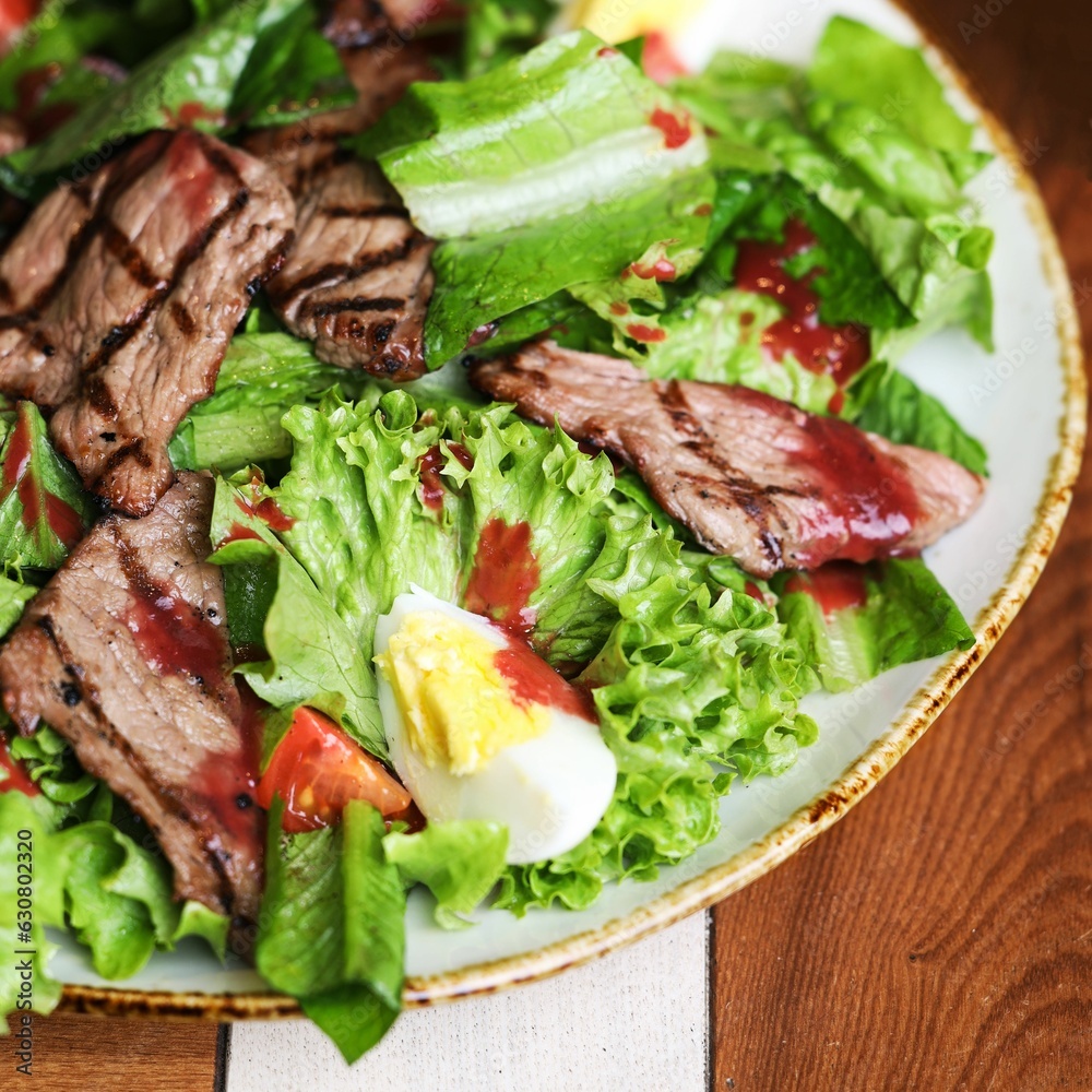 Closeup of a salad with lettuce leaves with beef and egg