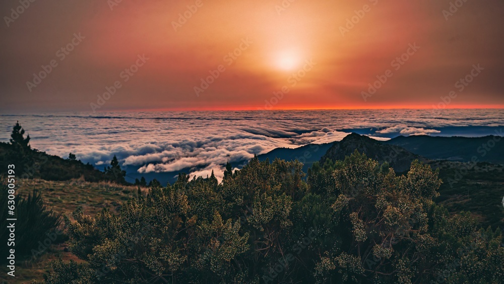 Stunning sunrise over a picturesque mountain range, with fluffy white clouds