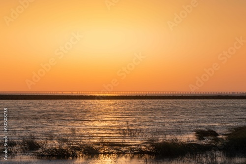 Stunning sunset view of a vast body of water, illuminated in a beautiful orange hue