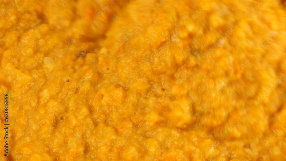 Stewed vegetables (carrots, onions, peppers and zucchini) are mixed until smooth in a glass bowl using an immersion blender. Preparing a vegetable snack. Stewed vegetables (carrots, onions, peppers and zucchini) are mixed until smooth in a glass bowl using an immersion blender. Preparing a vegetable snack.