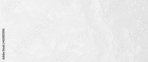 Ripple water texture on white background, shadow of water on sunlight, white water with ripples on the surface, defocus blurred transparent white colored clear calm water surface texture.