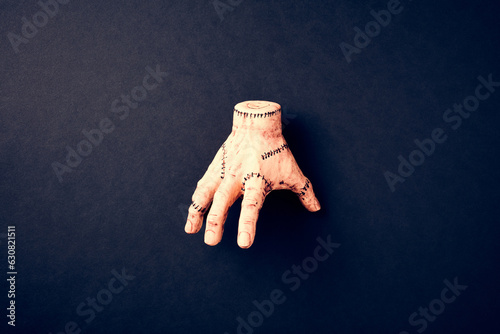 Severed hand Thing from Addams Family on dark background. Halloween holiday decoration.