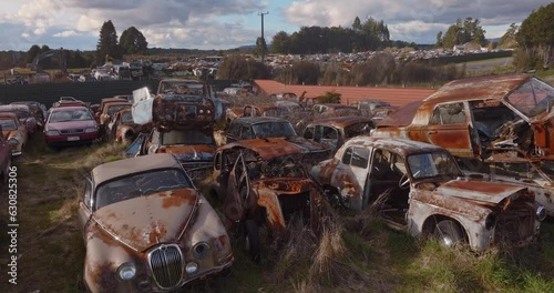 Aerial: Abandoned junk rusted cars in junkyard, New Zealand photo
