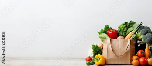 background of healthy food delivery. It features a paper bag filled with vegan and vegetarian food, including fruits and vegetables. has a white background with copy space, making it suitable for