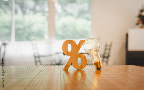 Light bulb with wooden percentage sign. Money management, financial plan, business idea and Creative ideas for saving money concept.
