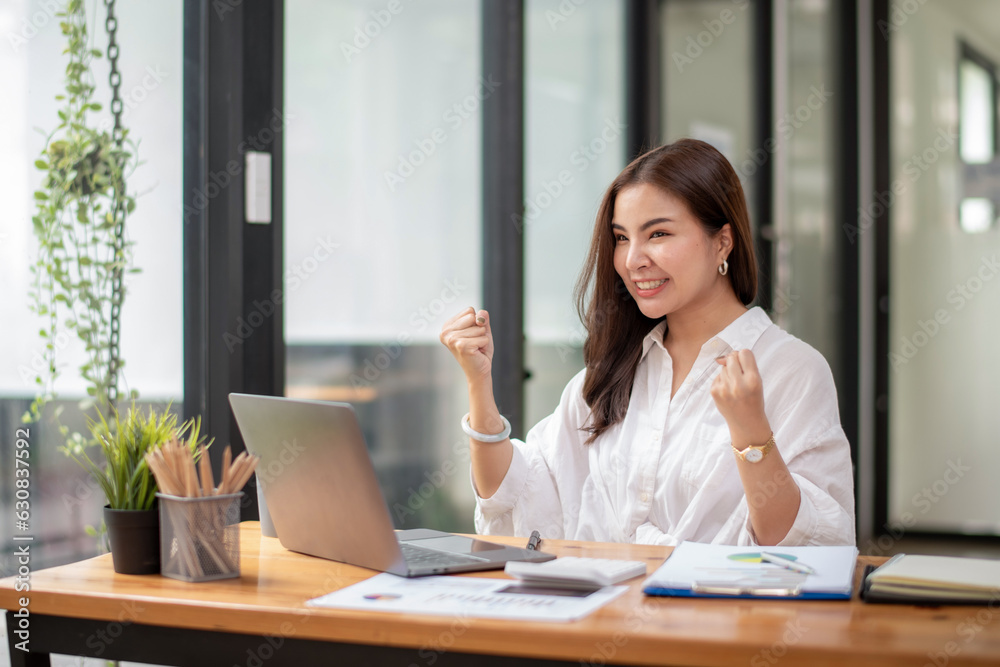 Happy businesswoman celebrating victory while receiving good news on her labtop, excited about success Happy businesswoman celebrating victory while receiving good news on her labtop, excited about success