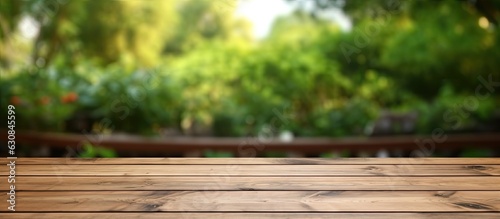 The wooden table is empty with a blurry outdoor garden background. It is a blank space for marketing promotion  with space for text.