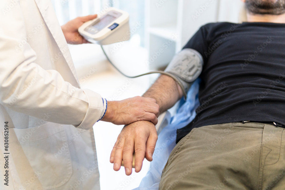 Obraz premium Doctor taking patient's blood pressure