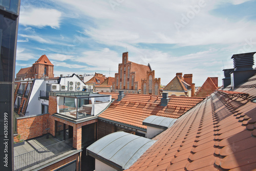 Roofs and brick buildings in the old town of Torun in Poland. The view from the terrace in sunny summer day.