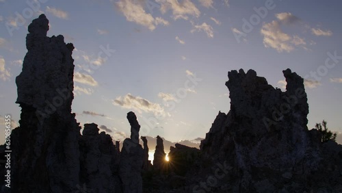 Silhouetted tufa rock formations against a sunrise sky with few clouds in the Eastern Sierra area of California