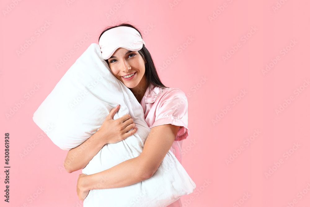 Young woman with sleeping mask hugging pillow on pink background Young woman with sleeping mask hugging pillow on pink background
