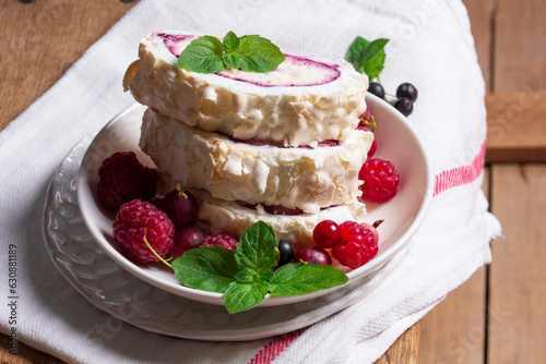 Obraz na płótnie Meringue roll with whipped cream and currant curd, served with berries on a ceramic plate. Rustic style. w salonie