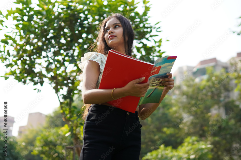 Low angle shot of Indian student studying in the campus Low angle shot of Indian student studying in the campus