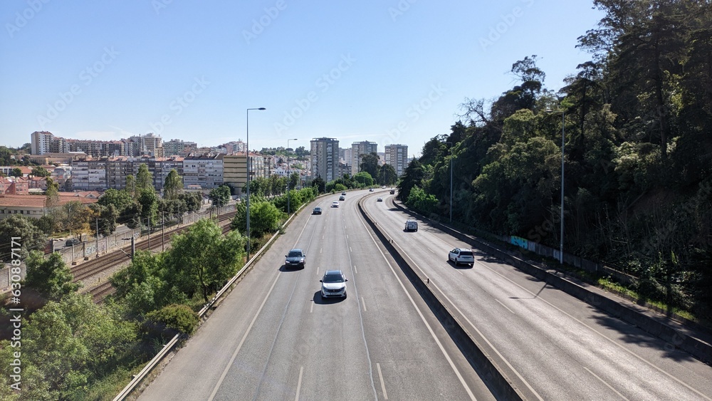 A long, wide expressway that runs between the park and the city of Lisbon