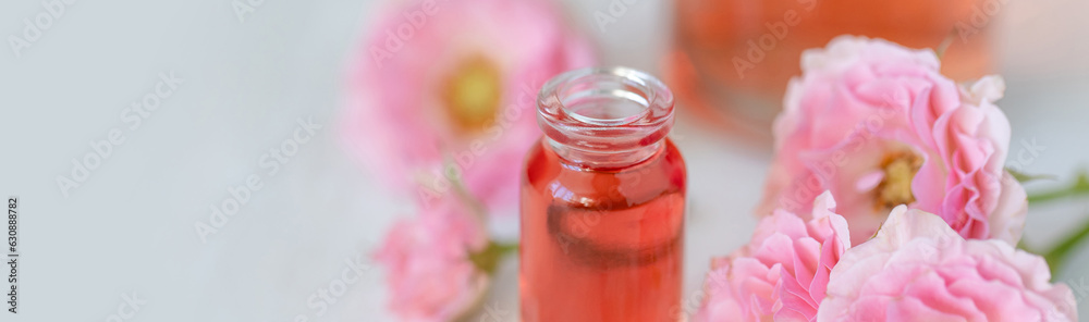 Premium skin care beauty treatment with pink rose petals. Plant-based pure organic ingredients in cosmetics. Jar of body or face moisturiser, lotion. Flower extract, natural youth anti-age elixir