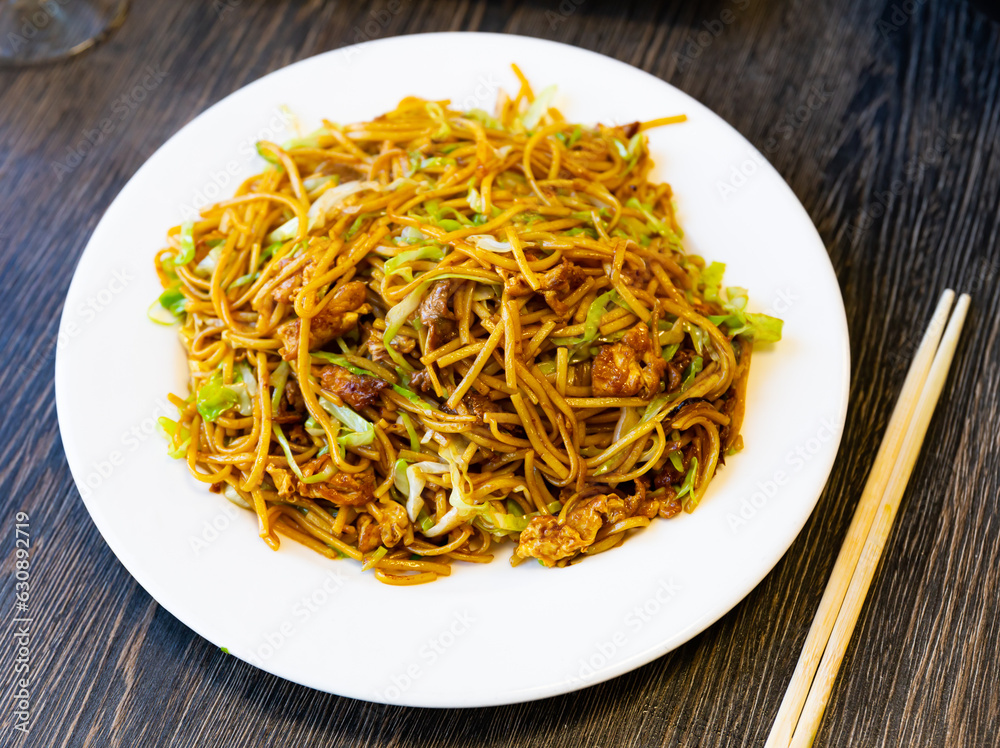 Delicious Chinese fried noodles served with vegetable pieces on plate