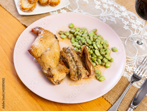 Appetizing fried rabbit on a plate with beans and parsley