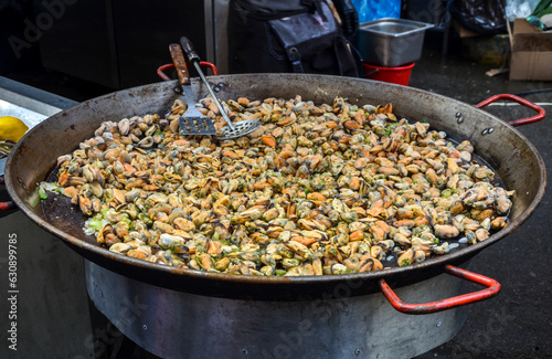 Large metal pan with heap of fresh frying clams cooking. Seafood. Delicious snack for gourmands
