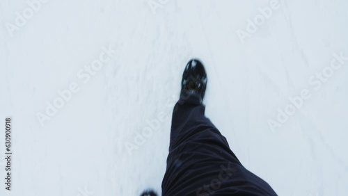 POV shot of traveller climbing snowy mountainside trekking path, going for a walk while enjoying winter holiday season. Tourist walking atop mountain hills slope covered by snow