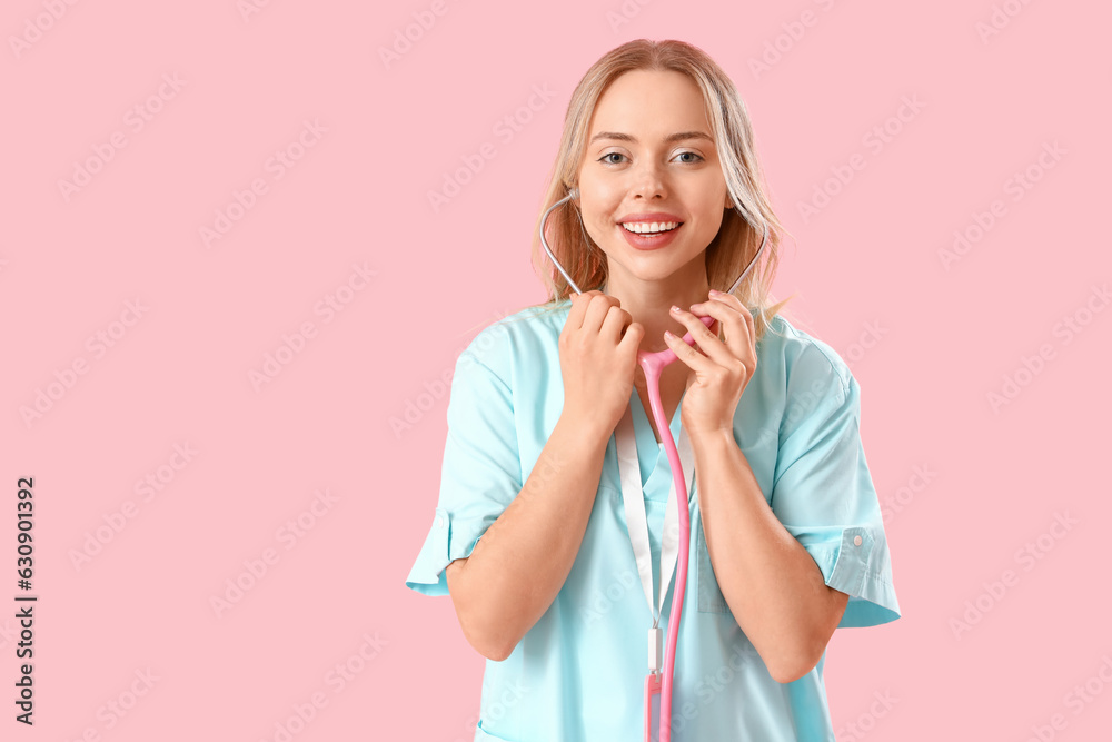 Female medical intern with stethoscope on pink background Female medical intern with stethoscope on pink background