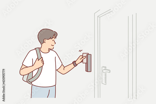 Man uses key card to open door to hotel room or hostel during tourist trip or business trip