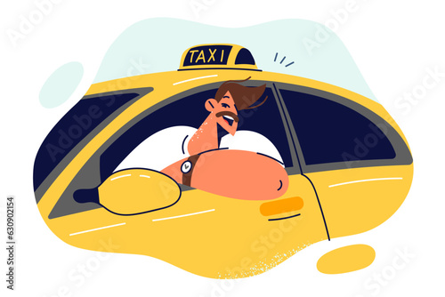 Man taxi driver smiles sitting behind wheel and looking out window of yellow car