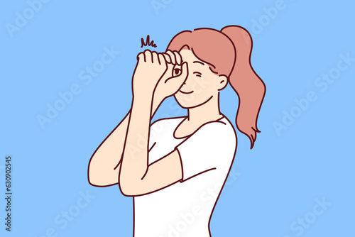 Woman looks through invisible spyglass with curiosity and wanting to know what is happening in distance. Inquisitive girl feels curiosity and puts hands to eyes watching world around her.
