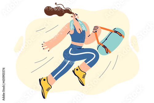 Happy athletic woman in sportswear holding bag with workout accessories and running to fitness club