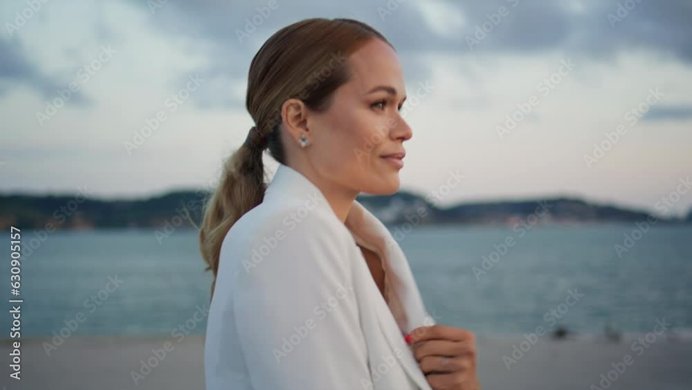 Pretty lady going embankment at cloudy evening close up. Woman walking coast Pretty lady going embankment at cloudy evening close up. Woman walking coast