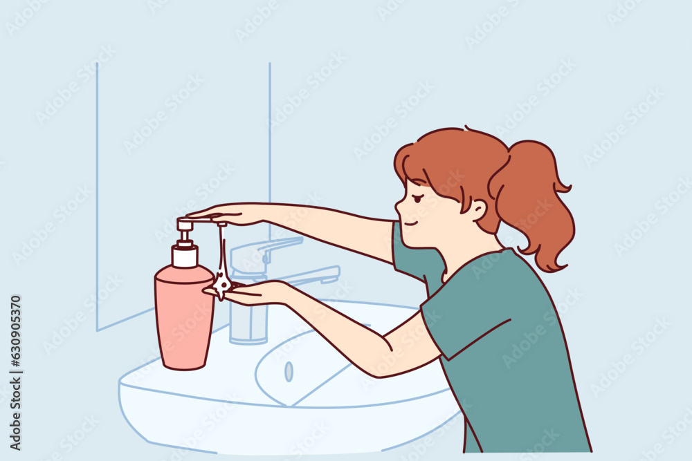 Little girl uses liquid soap to wash hands standing near sink and mirror in bathroom. Child follows hygiene rules with smile and washes hands with soap after coming home from school. Little girl uses liquid soap to wash hands standing near sink and mirror in bathroom. Child follows hygiene rules with smile and washes hands with soap after coming home from school.