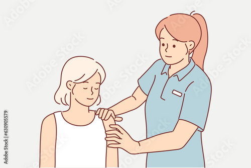 Woman fitness instructor massages shoulder of athlete helping to warm up before training