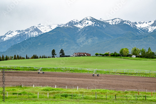Rural Farm House in front of Wallowa Mountains on Green Rolling Hills in Countryside of Eastern Oregon