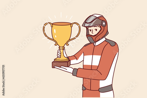 Man racer with golden cup for winning tournament rejoices at receiving championship title in competition. Guy driver, participant in extreme races on cars, demonstrates trophy of racer