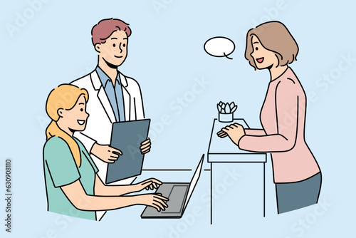 Woman client of clinic stands near reception desk and consults with doctor or chooses convenient time for next appointment. Employees of cosmetology clinic and potential patient are in lobby