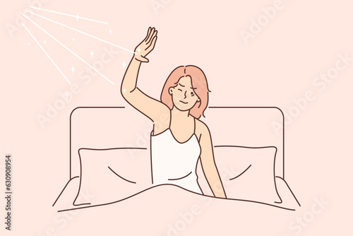 Morning awakening of woman dissatisfied with sun rays that interfere with sleep in bed