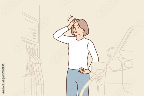 Shocked woman filling car at gas station opens mouth at high price of fuel driven up by inflation