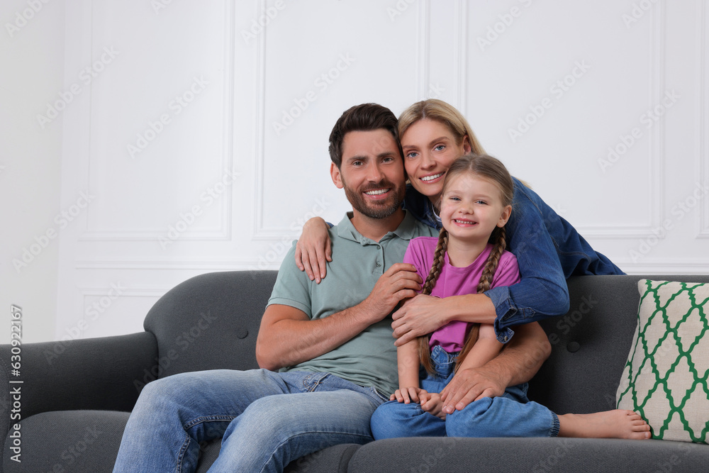 Portrait of happy family with child on sofa at home Portrait of happy family with child on sofa at home