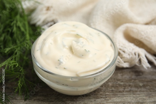Tablou pe pânză Tasty creamy sauce and fresh dill on wooden table, closeup