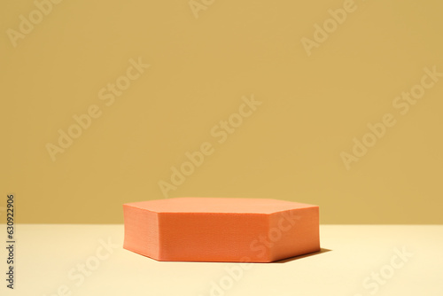 Orange stand on table against yellow background, space for text. Stylish presentation for product