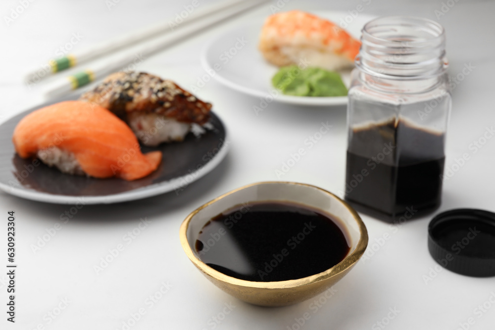 Tasty soy sauce and sushi on white marble table Tasty soy sauce and sushi on white marble table