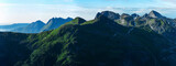 Panorama of green norwegian mountains seen from Smaltinden, Luröy, Helgeland, Nordnorge. High resolution fjell landscape. Norway sharp peaks in summer. Arctic coast of scandinavia. Grean cliffs tur