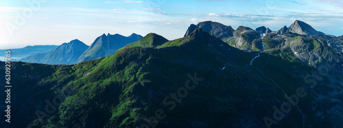Panorama of green norwegian mountains seen from Smaltinden, Luröy, Helgeland, Nordnorge. High resolution fjell landscape. Norway sharp peaks in summer. Arctic coast of scandinavia. Grean cliffs tur